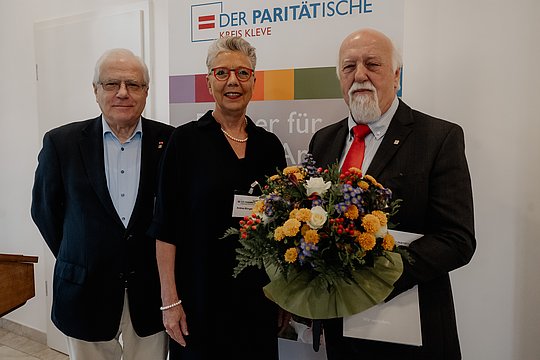 Karl-Peter Röhl mit Blumenstrauß. gemeinsam mit Frau Büngeler und Herrn Wolter