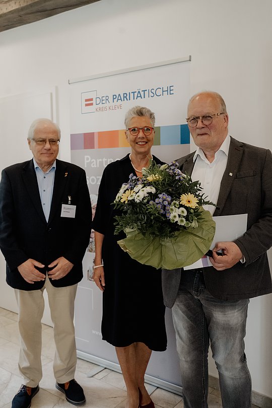 Kay Tödter mit Blumenstrauß. gemeinsam mit Frau Büngeler und Herrn Wolter