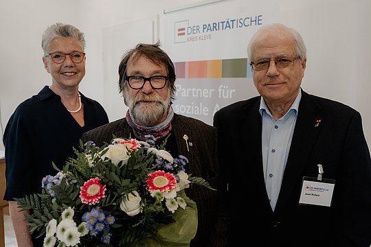 Uwe Fröhlich mit Blumenstrauß. gemeinsam mit Frau Büngeler und Herrn Wolter