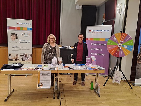 Heidi Graf von der der EUTB und Sabine Vermeulen von der Selbsthilfe-Kontaktstelle stehen hinter ihrem Infostand