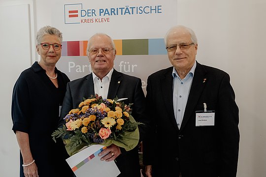 Udo Spelleken mit Blumenstrauß. gemeinsam mit Frau Büngeler und Herrn Wolter